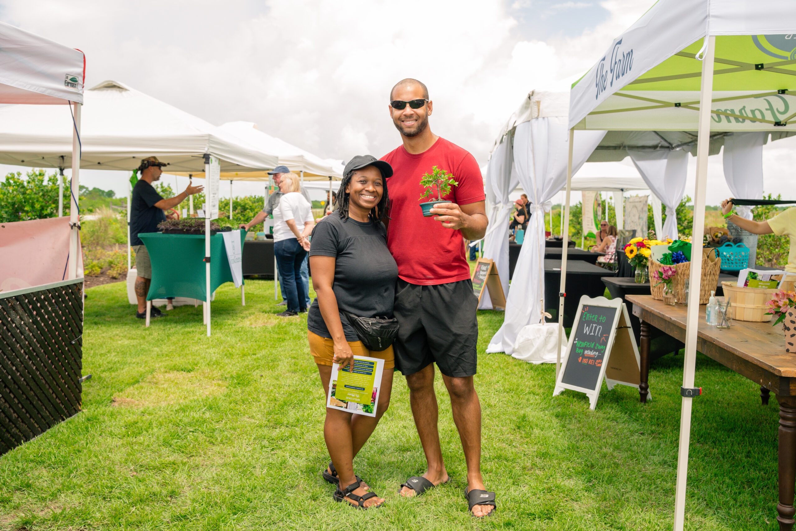 A couple proudly holding the plant they purchased from the farmers market at Newfield in Martin County